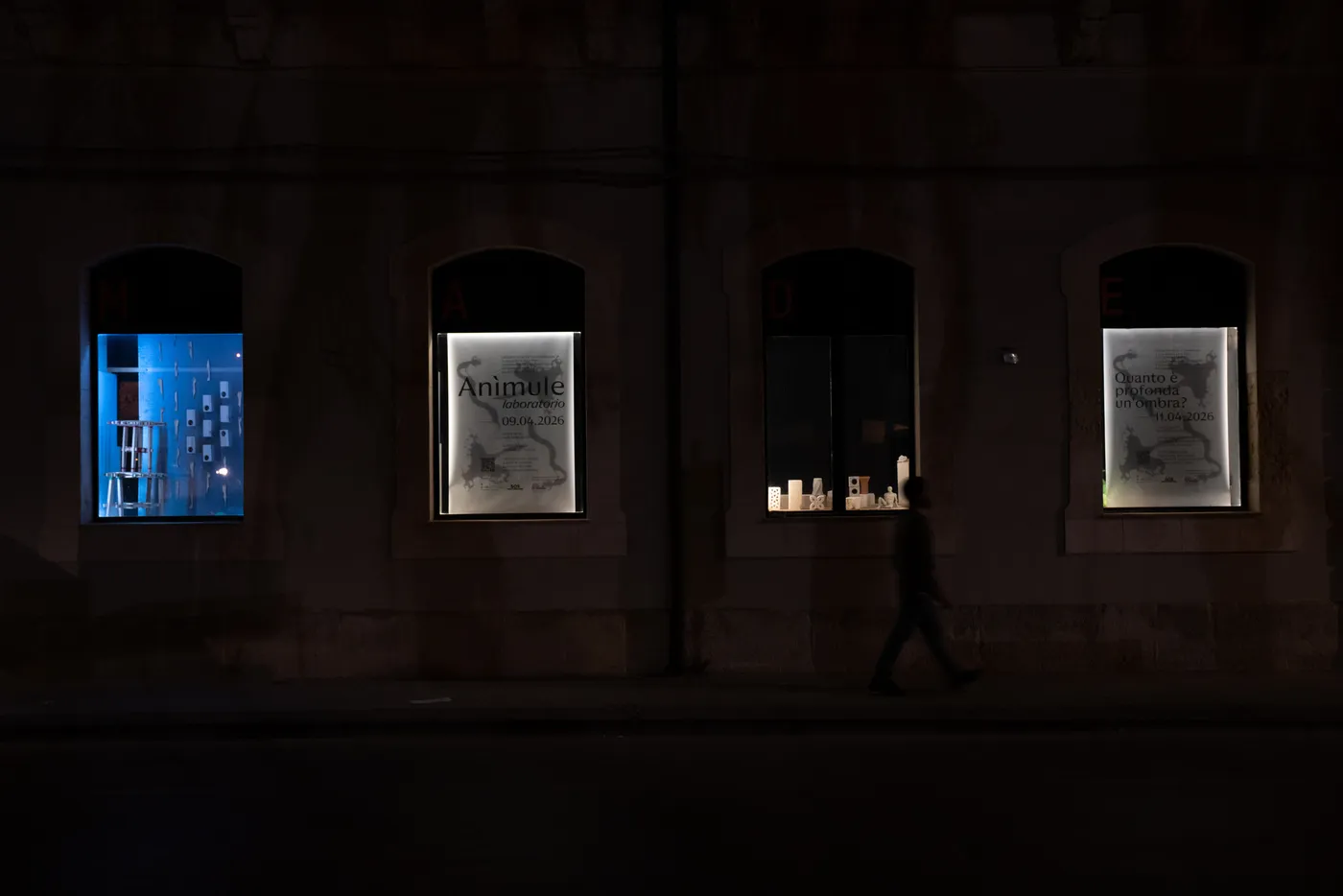The lit posters in the academy windows at night
