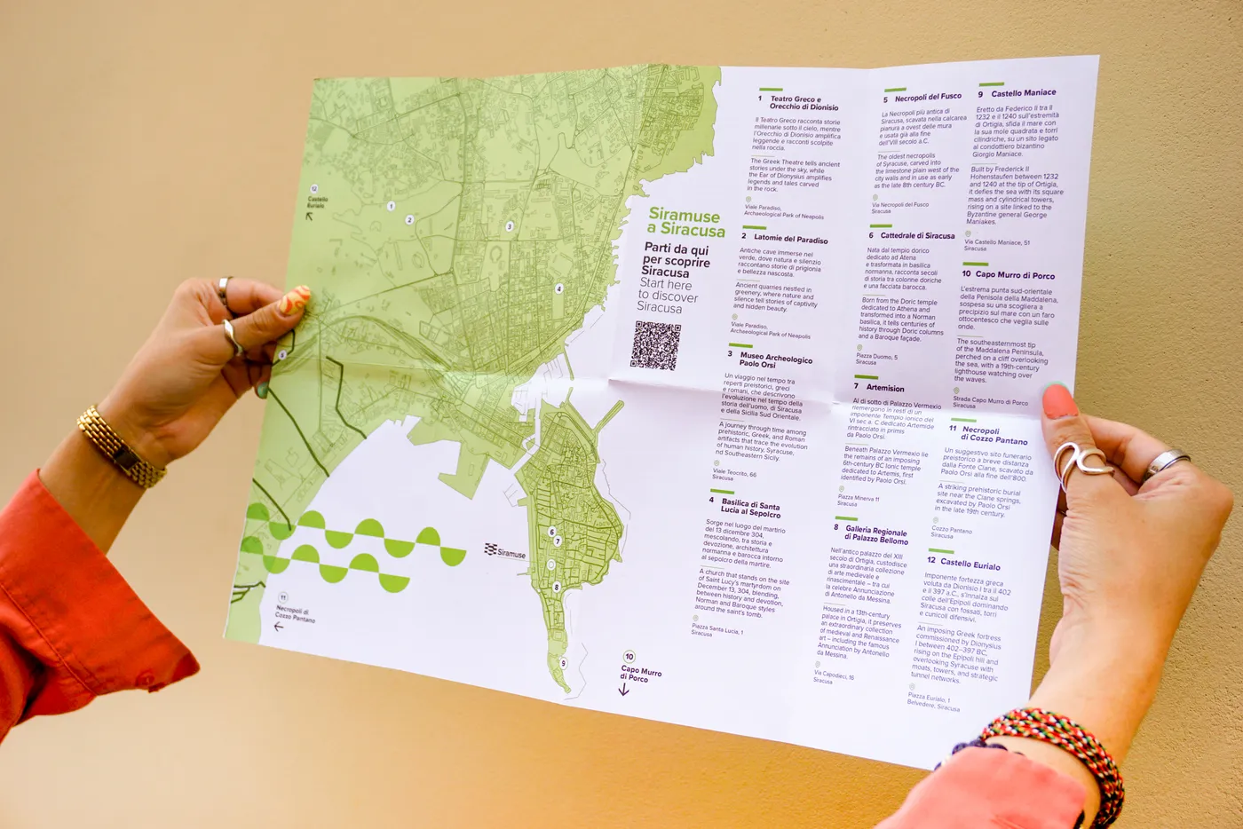 The green Siramuse city map unfolded in someone’s hands